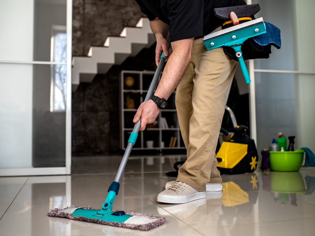 Technician installing a ceiling light fixture in a living room